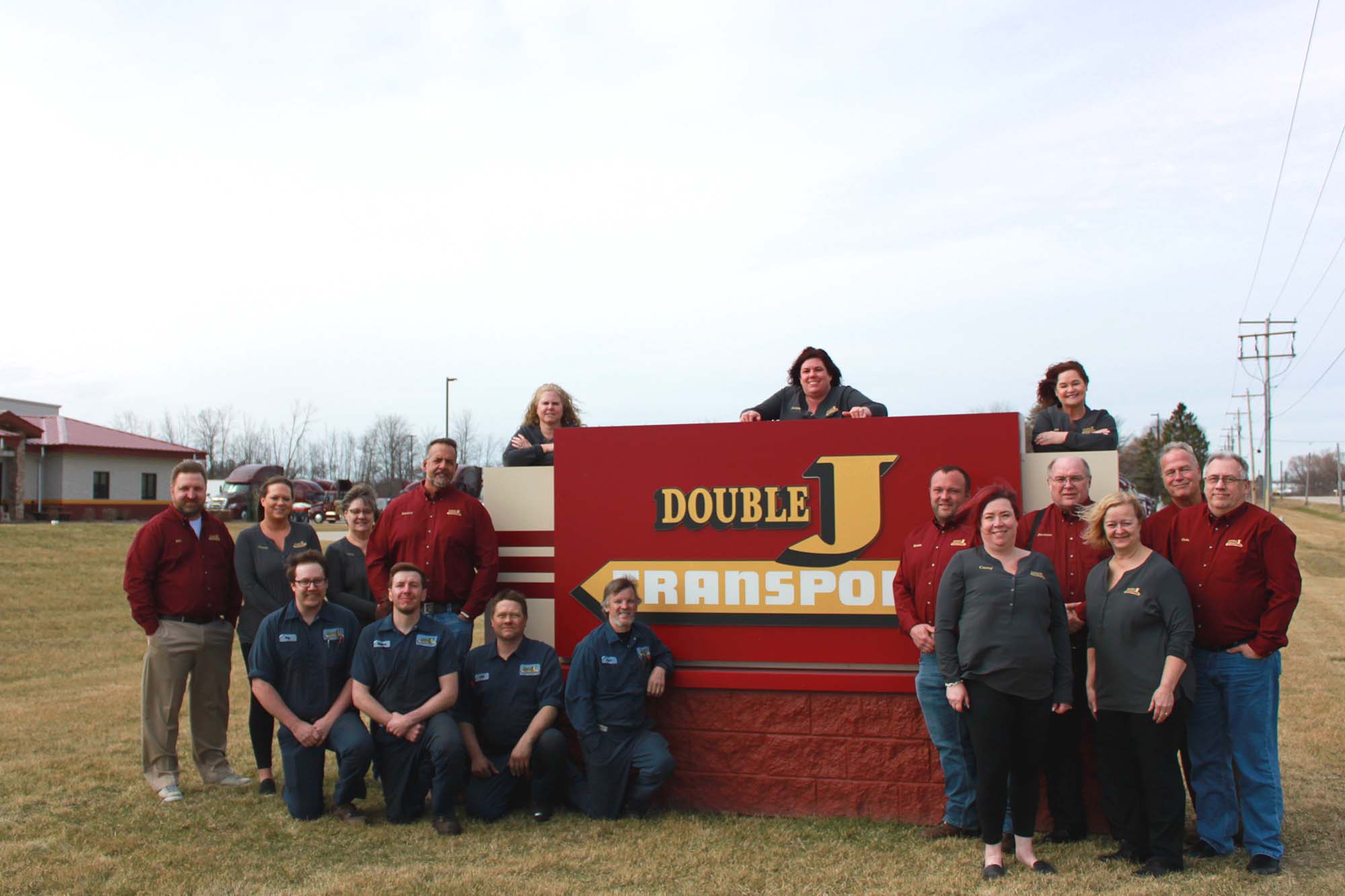 Double J team infront of the double j transport sign